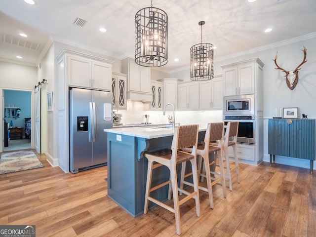 kitchen with a sink, visible vents, stainless steel appliances, and light countertops