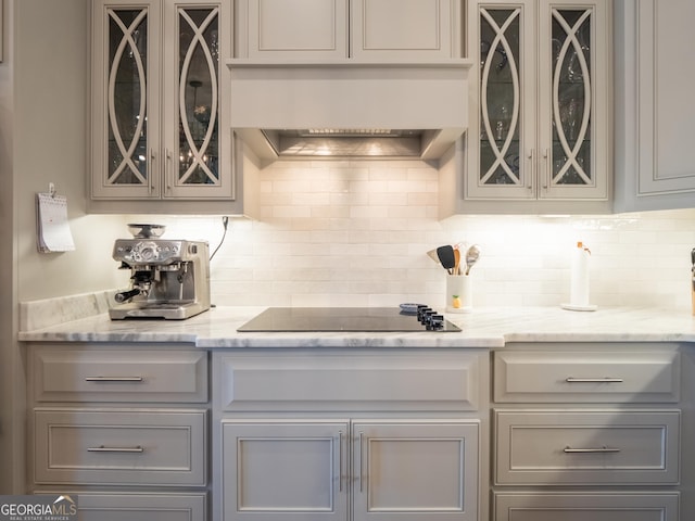 kitchen with custom range hood, black electric stovetop, and gray cabinetry