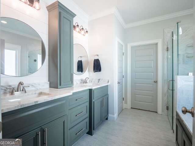 full bathroom with ornamental molding, a sink, a shower stall, and double vanity