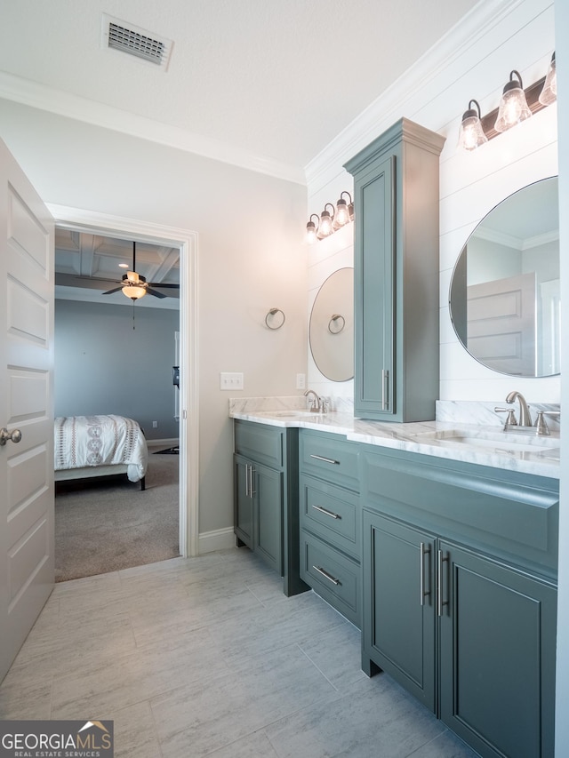 bathroom with connected bathroom, a sink, visible vents, ornamental molding, and double vanity