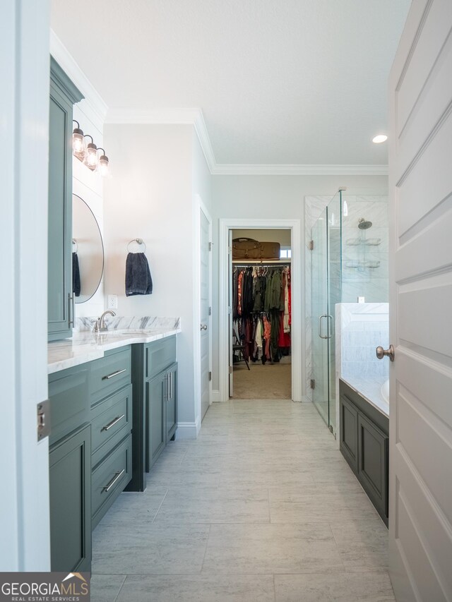 full bathroom featuring a garden tub, vanity, a shower stall, a walk in closet, and crown molding