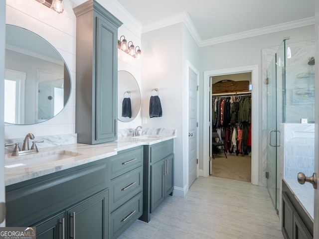 bathroom featuring a stall shower, ornamental molding, and a sink