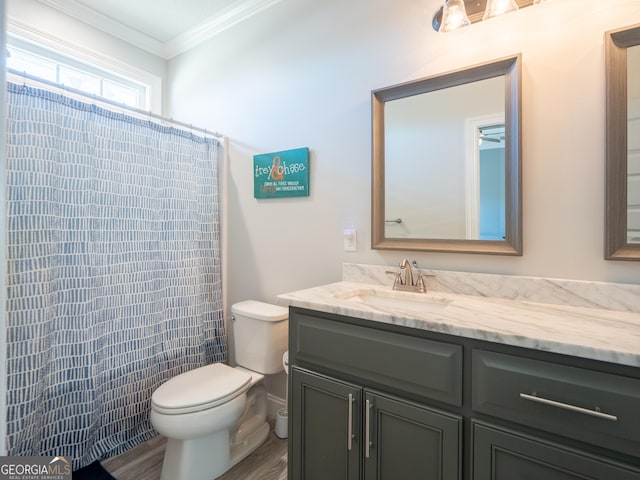 bathroom featuring curtained shower, toilet, ornamental molding, vanity, and wood finished floors