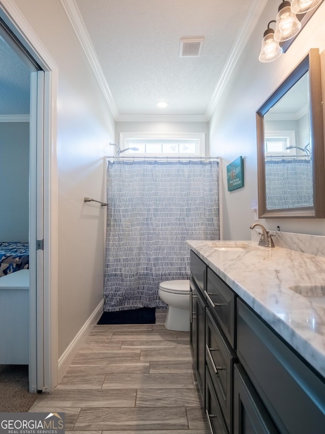 bathroom featuring ornamental molding, curtained shower, visible vents, and a sink