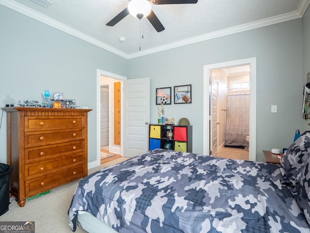 bedroom featuring ceiling fan, ornamental molding, carpet flooring, and connected bathroom