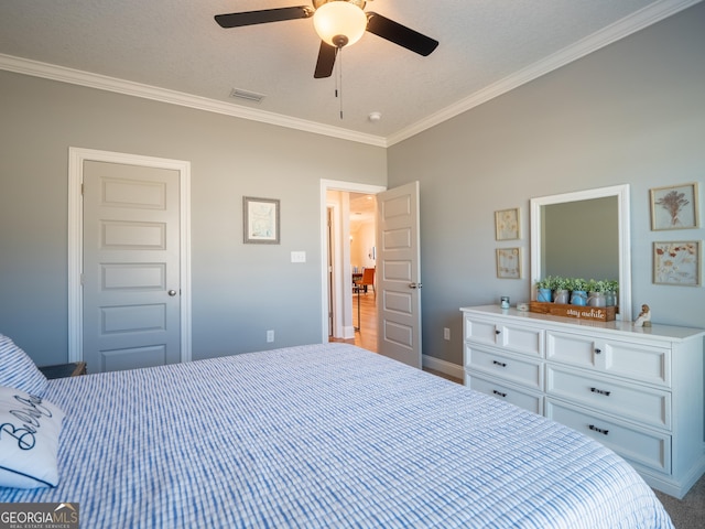 bedroom featuring a ceiling fan, visible vents, crown molding, and baseboards