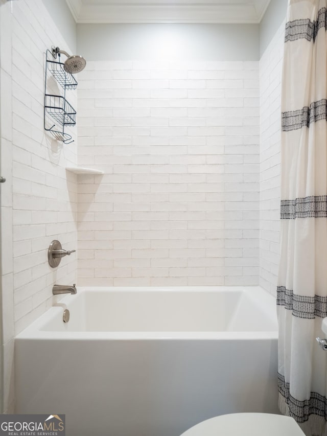 bathroom featuring toilet, ornamental molding, and shower / tub combo with curtain