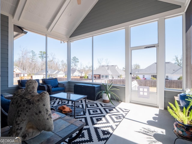 sunroom / solarium featuring a residential view and vaulted ceiling