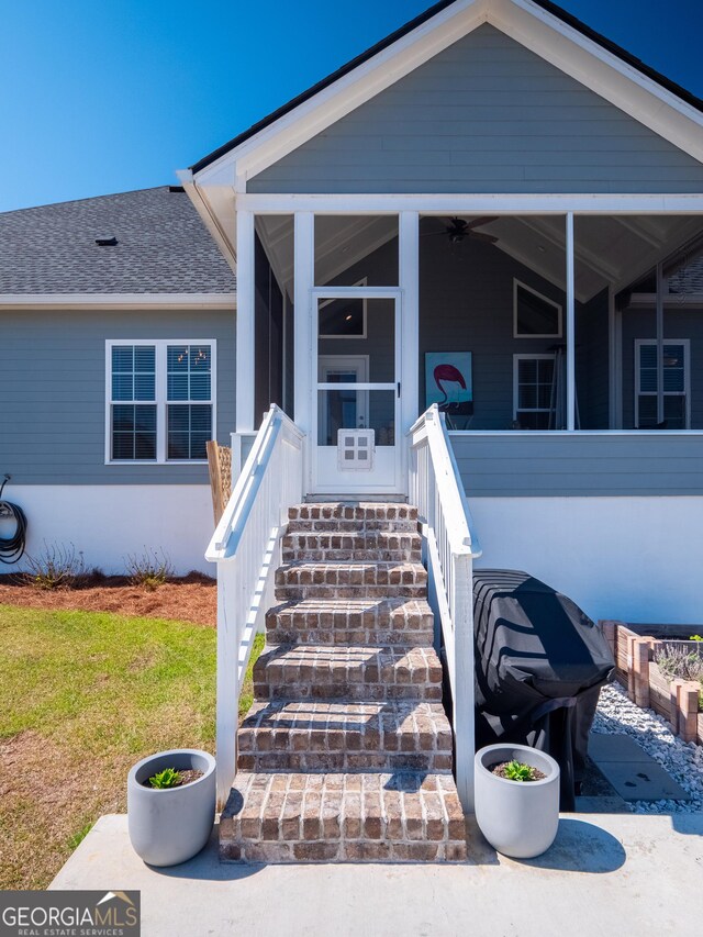 entrance to property featuring roof with shingles