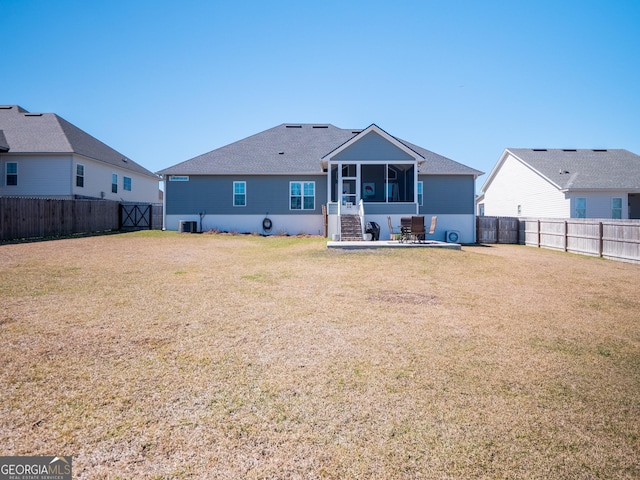 back of property featuring a lawn, cooling unit, a sunroom, and a fenced backyard