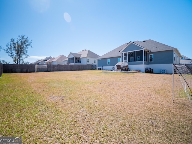 view of yard with a sunroom and a fenced backyard