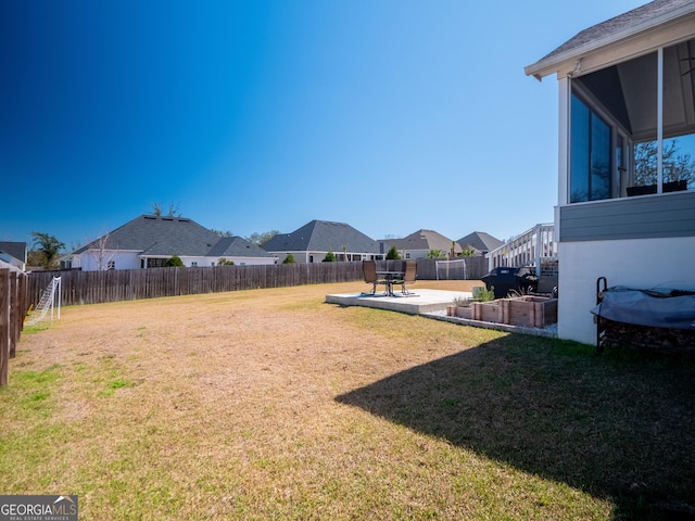 view of yard featuring a patio area, a fenced backyard, a residential view, and a sunroom