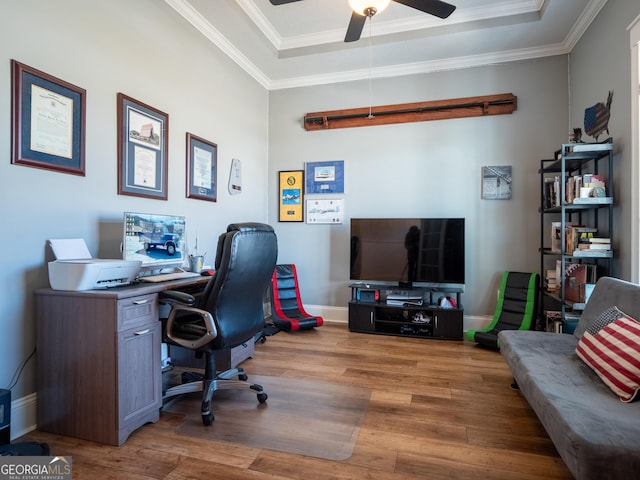 office with a tray ceiling, crown molding, a ceiling fan, wood finished floors, and baseboards