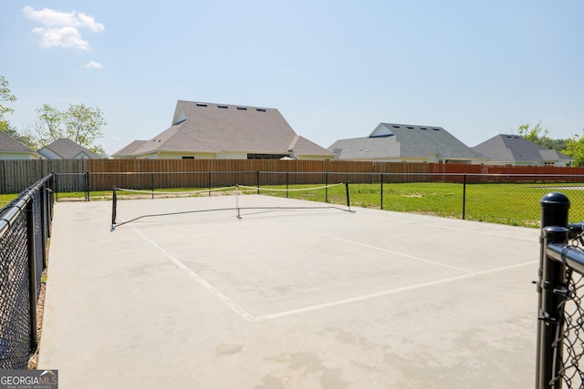 view of sport court featuring a lawn and fence