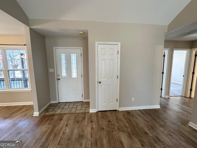 foyer entrance with visible vents, baseboards, and dark wood-style flooring