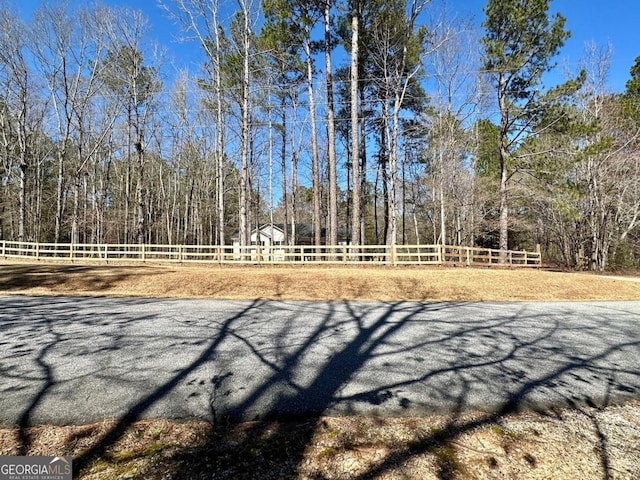 view of property's community featuring a wooded view and fence