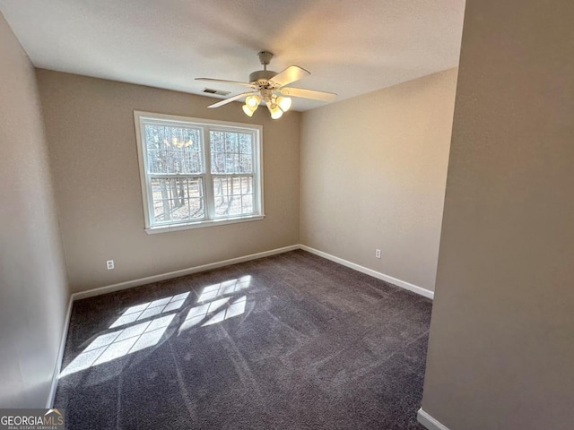 unfurnished room with carpet floors, baseboards, visible vents, and a ceiling fan