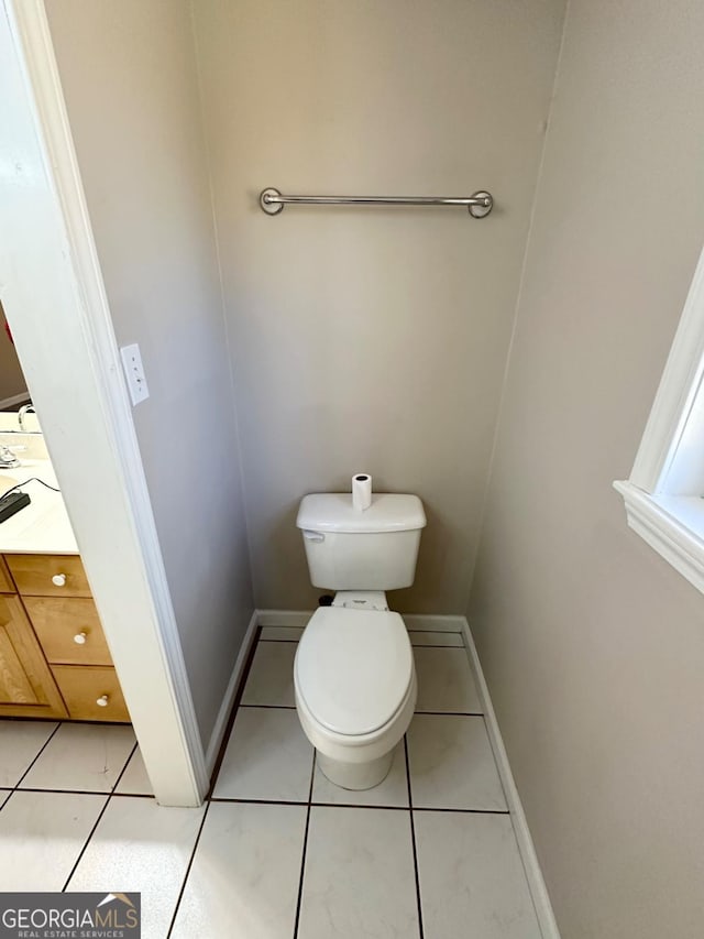 bathroom featuring baseboards, toilet, and tile patterned floors