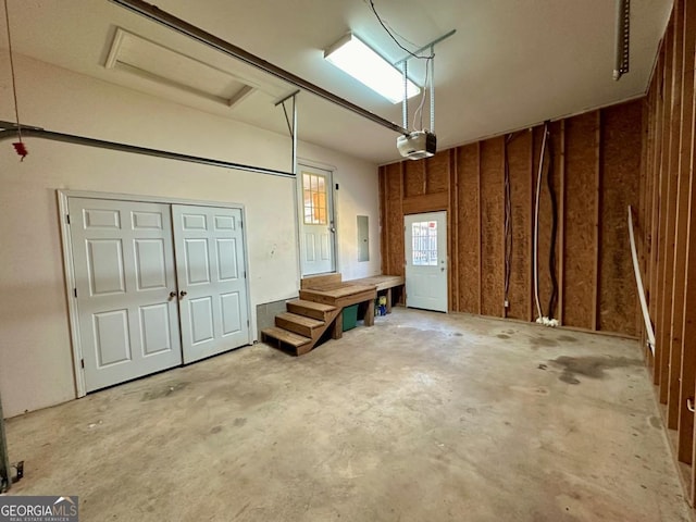 garage with a garage door opener and electric panel