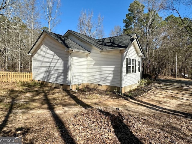 view of side of home featuring crawl space and fence