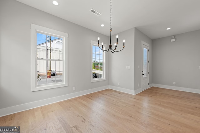 unfurnished dining area featuring baseboards, visible vents, and light wood finished floors