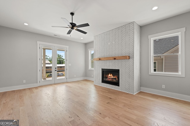 unfurnished living room with baseboards, light wood finished floors, a fireplace, and recessed lighting