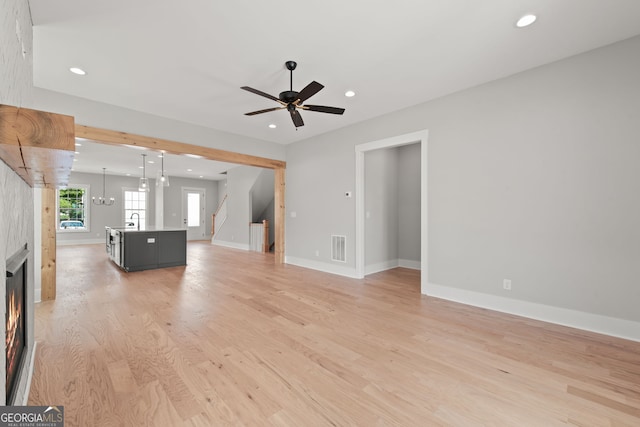 unfurnished living room featuring recessed lighting, a large fireplace, visible vents, baseboards, and light wood-type flooring