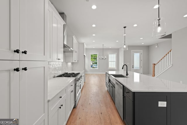 kitchen with a large island, appliances with stainless steel finishes, a sink, white cabinetry, and backsplash