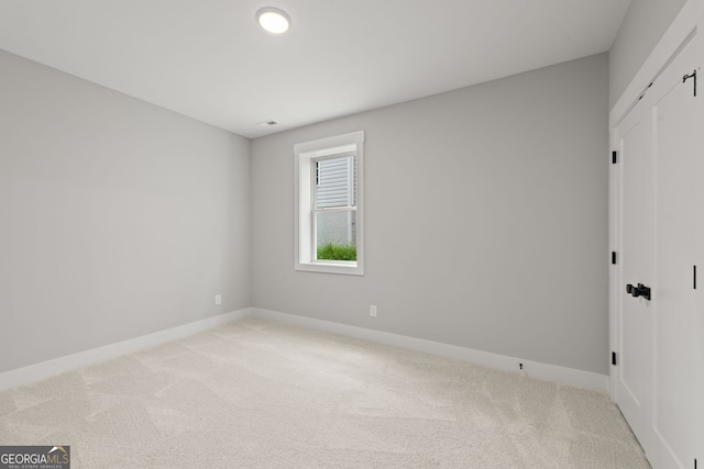 unfurnished bedroom featuring baseboards and light colored carpet