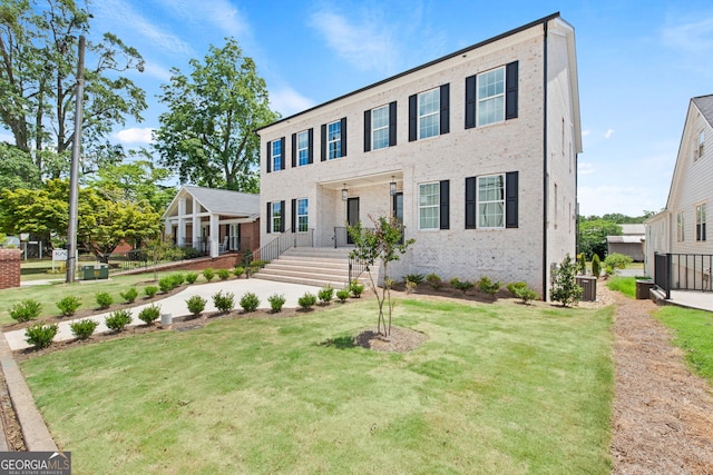 view of front facade featuring a front yard and brick siding