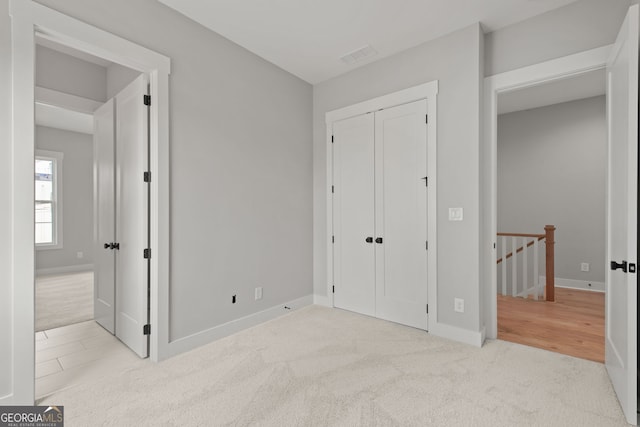 carpeted bedroom featuring a closet, visible vents, and baseboards