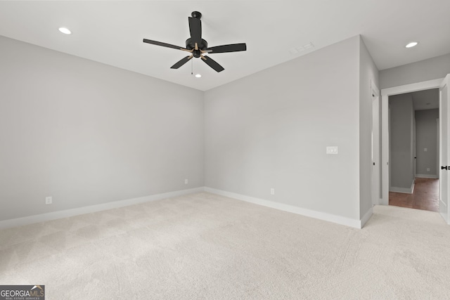 spare room with recessed lighting, light carpet, ceiling fan, and baseboards