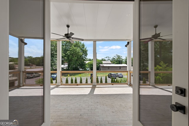 sunroom / solarium featuring a ceiling fan