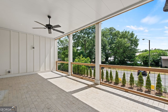 unfurnished sunroom featuring a ceiling fan