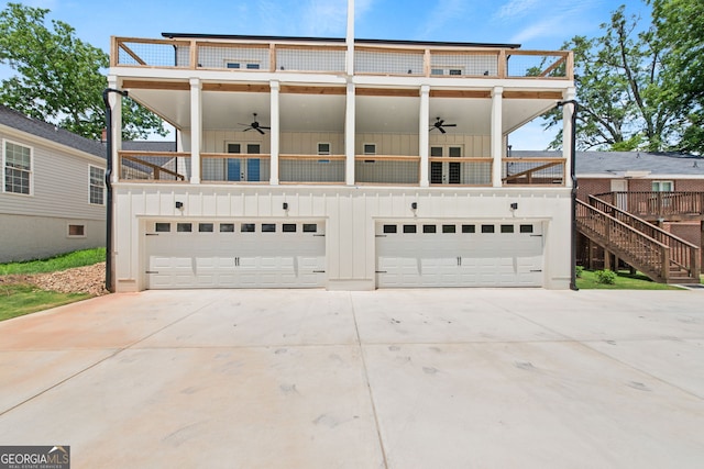 view of front of house featuring a balcony, a garage, a ceiling fan, driveway, and board and batten siding