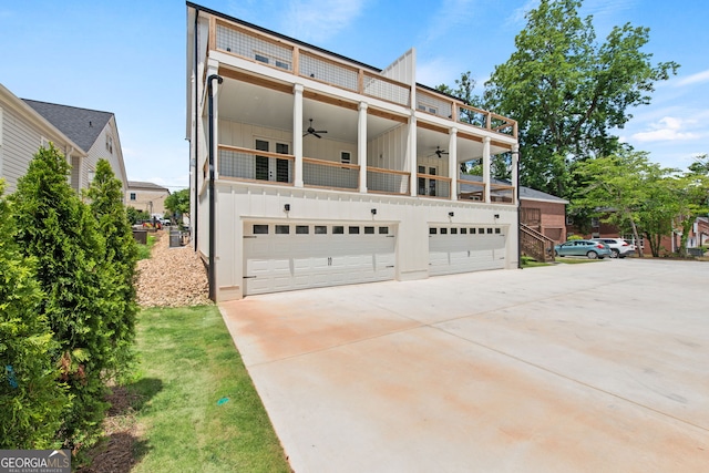 view of front of house featuring driveway, a garage, a balcony, ceiling fan, and board and batten siding