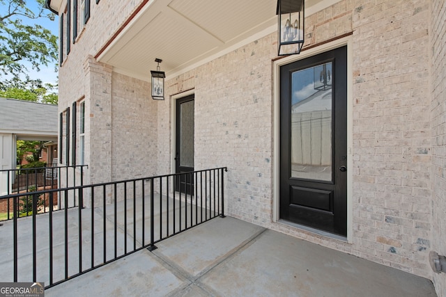 view of exterior entry featuring brick siding