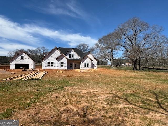 rear view of house with a lawn and an outdoor structure