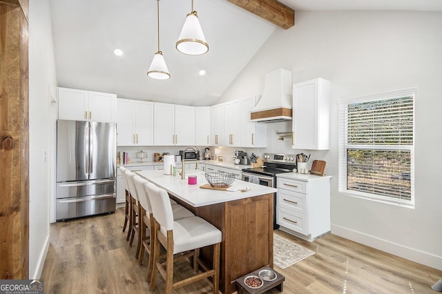 kitchen with beamed ceiling, stainless steel appliances, light countertops, premium range hood, and a kitchen bar