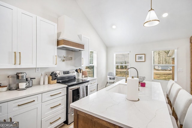 kitchen featuring lofted ceiling, stainless steel electric range oven, white cabinets, and a sink