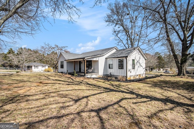 view of front of property featuring covered porch and a front lawn