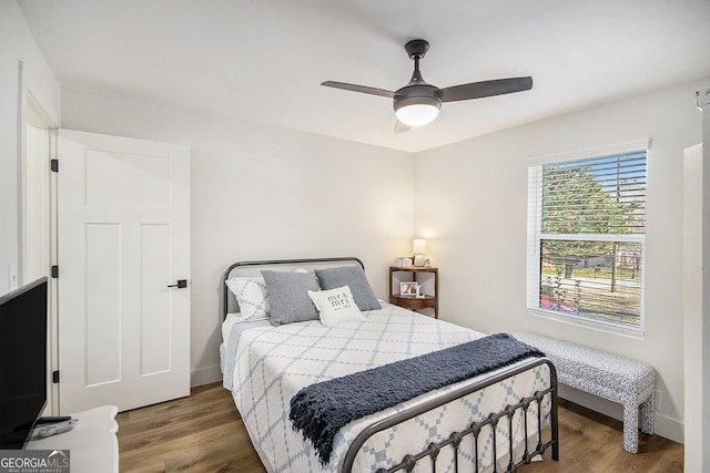 bedroom featuring baseboards, a ceiling fan, and wood finished floors