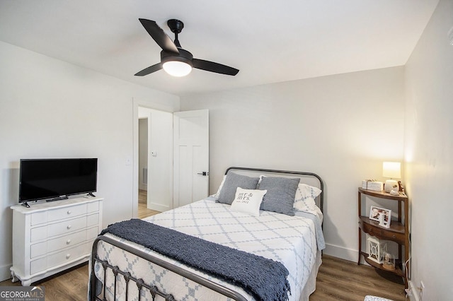 bedroom with wood finished floors, a ceiling fan, and baseboards