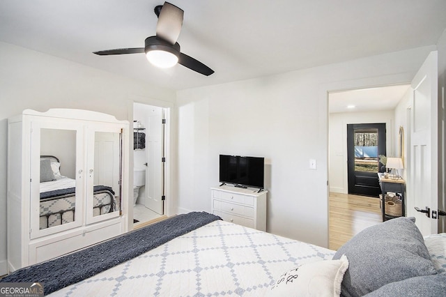 bedroom featuring ceiling fan, connected bathroom, baseboards, and wood finished floors