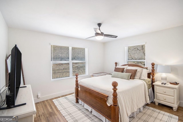 bedroom with light wood-type flooring, ceiling fan, and baseboards