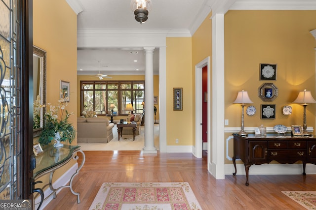 foyer entrance with ceiling fan, wood finished floors, baseboards, decorative columns, and crown molding