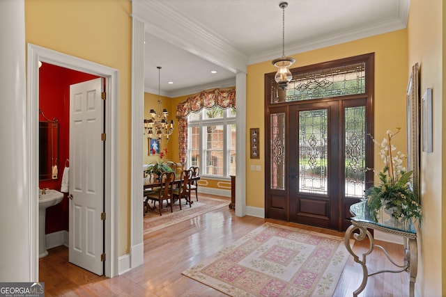 entrance foyer with baseboards, crown molding, light wood-type flooring, a chandelier, and recessed lighting