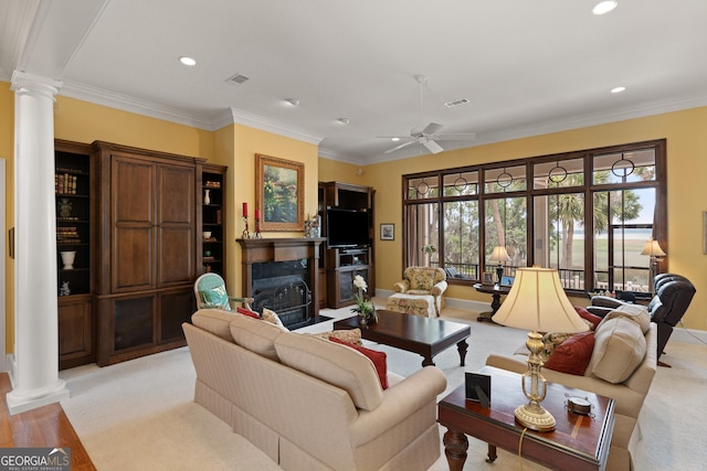 living area with visible vents, a fireplace, decorative columns, and crown molding