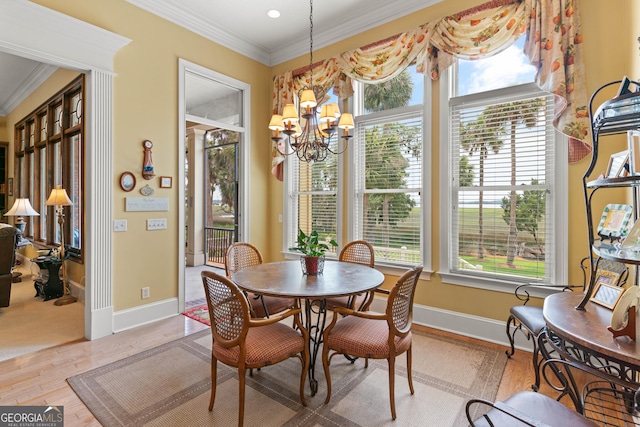 dining room with baseboards, ornamental molding, a chandelier, and wood finished floors