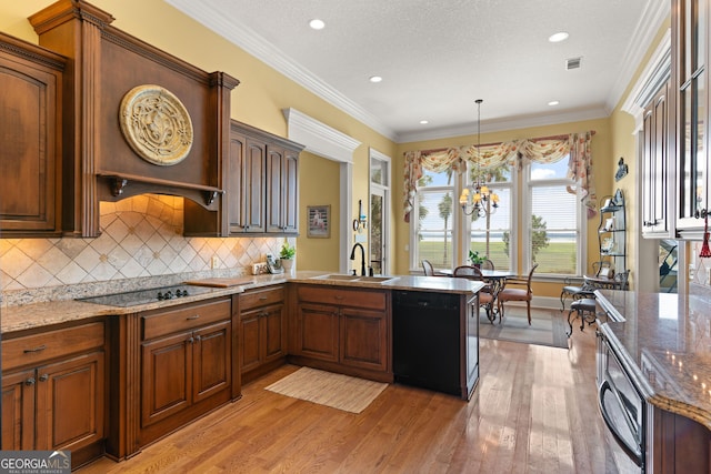 kitchen with black appliances, ornamental molding, light wood-style floors, and a sink